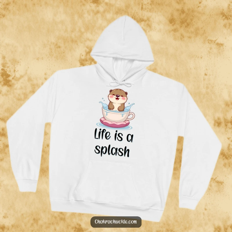 Funny hoodie featuring a happy otter joyfully splashing in a teacup-shaped meditation cushion, radiating warmth and fun.